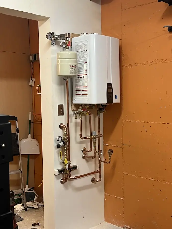 Plumbing technician inspecting water heater connections in Plainview